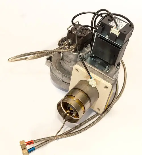Daikin Ölbrenner mit montierten Leitungen und einem elektrischen Anschluss, in einem technischen Aufbau sichtbar, auf hellem Hintergrund.